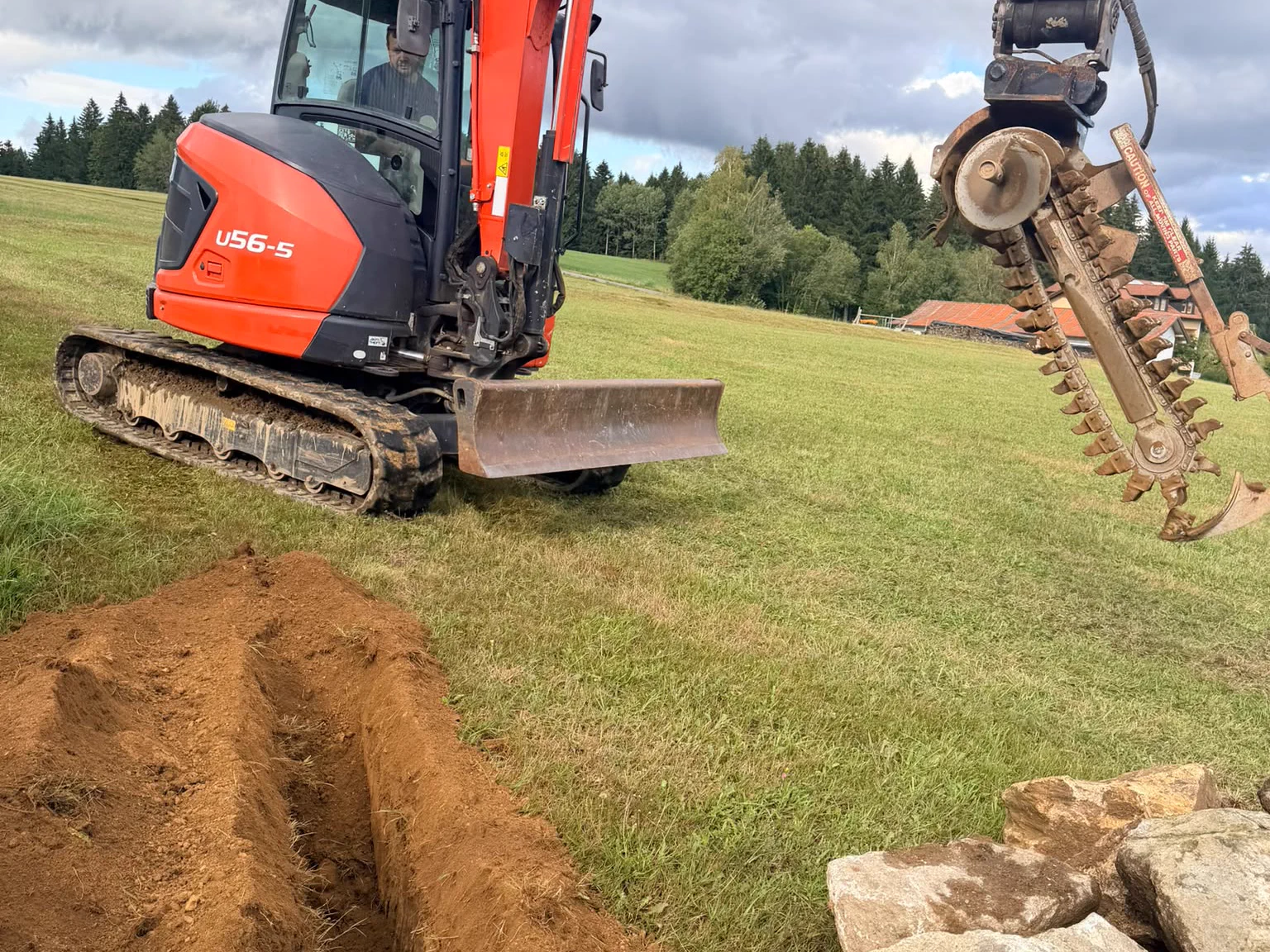 Kabelfräse am Kubota U56-5 von Fruth über einem frisch gefrästen, schmalen Leitungsgraben