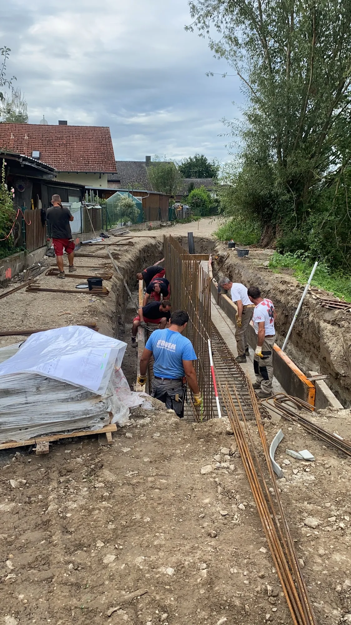 Handwerker-Team von Fruth beim Flechten der Fundamentbewehrung im Graben